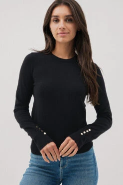 Le Chandail Noir Avec Détails De Boutons Aux Manches